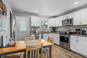a kitchen with white cabinets and a wooden table at The Bamboo Bungalow in Hendersonville