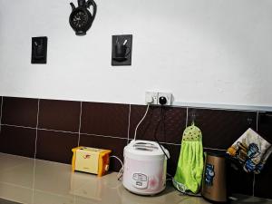 una encimera de cocina con tostadora y un reloj en la pared en VIRTA Guesthouse, en Sandakan