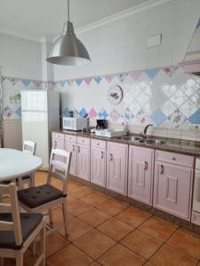 a kitchen with pink cabinets and a table at Mar in Isla del Moral
