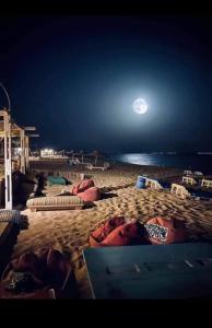einen Strand in der Nacht mit Vollmond am Himmel in der Unterkunft Tommy Tour Sahara in Ad-Dakhla