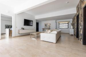 a living room with a white couch and a table at Villa Serenity in Tías