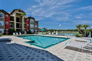 a swimming pool with chairs and a building at Villa del Sol #324 in Kissimmee