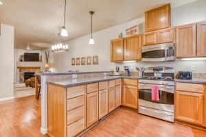 a kitchen with wooden cabinets and stainless steel appliances at Creek Ridge Escape in Government Camp