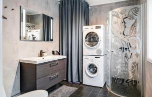 a bathroom with a washer and dryer next to a sink at Hytte Trysil SPA in Trysil