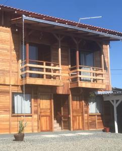 ein Holzgebäude mit Balkon auf der Seite in der Unterkunft Hospedagem Praia Cozinha Piscina Beto Carrero World in Piçarras