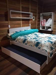 Bett mit blauer Decke in einem Zimmer in der Unterkunft Hospedagem Praia Cozinha Piscina Beto Carrero World in Piçarras