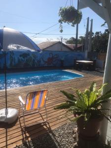 einen Stuhl auf einer Terrasse neben einem Pool in der Unterkunft Hospedagem Praia Cozinha Piscina Beto Carrero World in Piçarras