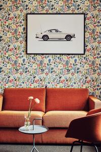 a living room with a couch and a picture of a car at NOFO Hotel, WorldHotels Crafted in Stockholm