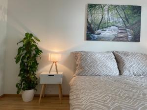 a bedroom with a bed with a plant and a lamp at 55m2 Modern Flat with Balcony in Vienna