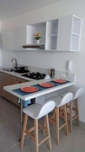 una cucina con bancone, sgabelli e lavandino di Apartaestudio Reserva del Mar Playa Salguero Santa Marta a Santa Marta