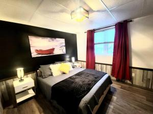 sypialnia z dużym łóżkiem i oknem w obiekcie Nouveau * Bord de lac * spa, foyer, Netflix et + w mieście Hébertville