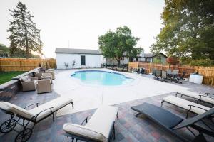 eine Terrasse mit Stühlen und einen Pool mit einem Zaun in der Unterkunft Luxury 5 bedroom home with Pool. in Overland Park