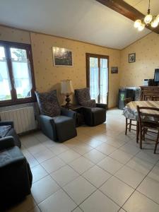 - un salon avec des canapés, une table et des chaises dans l'établissement Maison cosy proche de font romeu, à Latour-de-Carol