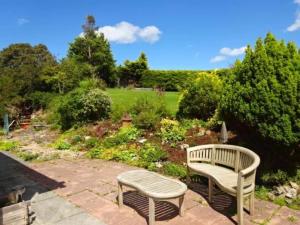 einen Park mit einer Bank und einem Garten in der Unterkunft Jaw-Dropping Beach House In Anglesey in Benllech