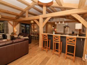 a kitchen and living room with wooden ceilings at Lady Bagots Cabin in Ruthin