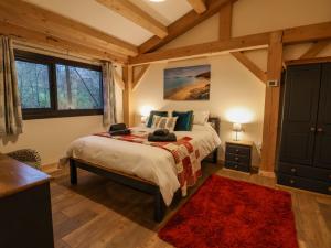 a bedroom with a bed with a red rug at Lady Bagots Cabin in Ruthin