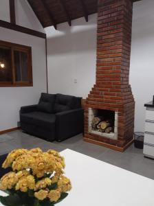 sala de estar con sofá y chimenea en Casa Medieval, en Gramado
