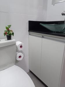 a white bathroom with a sink and a toilet at Casa Medieval in Gramado