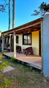 Un porche de una casa con dos bancos. en DiaBro's, en Punta del Diablo