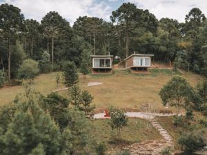 una casa en la cima de una colina con árboles en Refúgio Casa de Pedra en Cambara do Sul