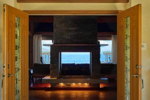 Private beach retreat Resort villa iki by ritomaru في إكي: موقد في غرفة المعيشة مع إطلالة على المحيط
