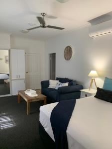 a hotel room with a bed and a couch at The Mediterranean Port Douglas in Port Douglas