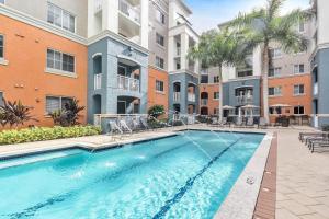 una piscina en un complejo de apartamentos con un edificio en Dharma Home Suites South Miami at Red Road Commons, en Miami