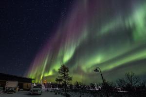 an image of the northern lights in the sky at Tupasvilla in Saariselka