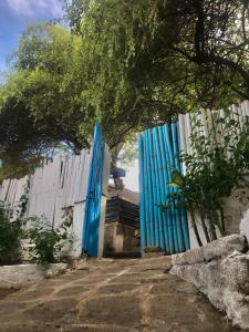 un portail bleu devant une clôture blanche dans l'établissement The House Hostel, à Gili Trawangan