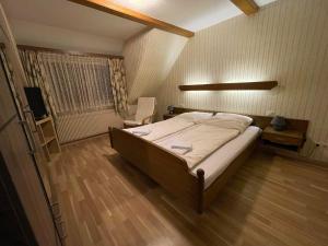Beny Hotel Restaurant في باد بيلنغن: غرفة نوم فيها سرير وكرسي