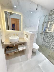 マラガにあるLuna Ensuites Centroの洗面台、トイレ、鏡のあるバスルーム +16枚の写真