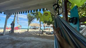 una persona tumbada en una hamaca en una playa en Friendly Kite School, hotel and bar, en Villa Vásquez