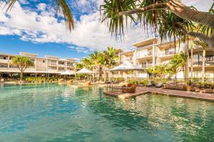 una piscina in un resort con palme e edifici di Peppers Plunge Pool Perfection 2br spa suite a Kingscliff