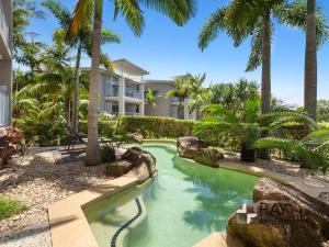 una piscina in un resort con palme di Peppers Plunge Pool Perfection 2br spa suite a Kingscliff