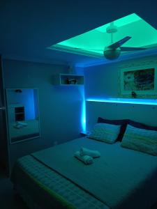 um quarto com uma cama com luz verde em ** SUITE PRIVATIVA PRAIA DO FORTE CABO FRIO ** em Cabo Frio