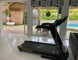 a treadmill sitting in a living room next to a couch at 4 Bedroom Samui Family Pool Villa in Bophut 
