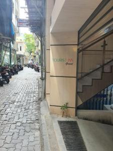 a cobblestone street next to a building with a store at Tourist Inn Grand in Male City