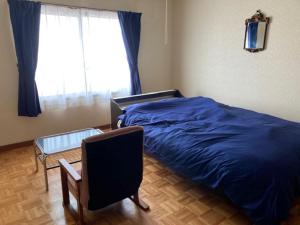 a bedroom with a bed and a chair and a window at SPR港家 in Kamuenai +5 photos