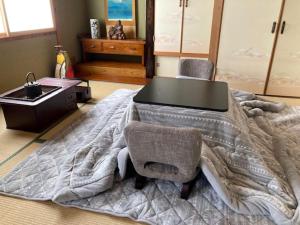 a bedroom with a large bed with a table and chairs at SPR港家 in Kamuenai