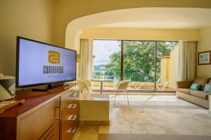 a living room with a flat screen tv on a cabinet at Camino Real Acapulco Diamante in Acapulco