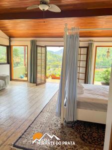 - une chambre avec un lit et une grande fenêtre dans l'établissement Casa Mirante do Prata no Vale das Videiras, à Petrópolis