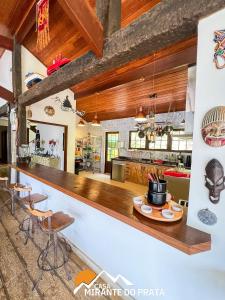 une cuisine avec un comptoir et un bar avec des tabourets dans l'établissement Casa Mirante do Prata no Vale das Videiras, à Petrópolis