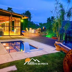 une villa avec une piscine la nuit dans l'établissement Casa Mirante do Prata no Vale das Videiras, à Petrópolis