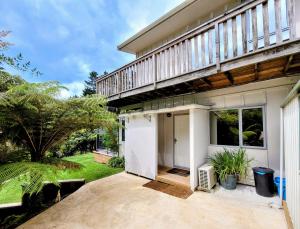 a house with a balcony on top of it at Garden Bliss & Bird Sanctuary in Paihia Estuary in Paihia