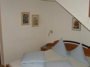 a bedroom with a white bed with blue pillows at Hotel Garni Löhr in Landau an der Isar