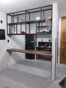 a kitchen with black cabinets and a wooden bench at FLAT PALLADIUM - DE FRENTE - novo in São Vicente