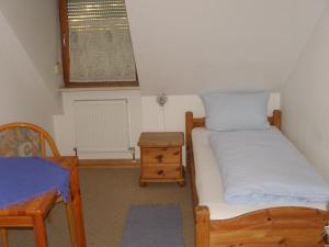 a small bedroom with two beds and a table at Hotel Garni Löhr in Landau an der Isar