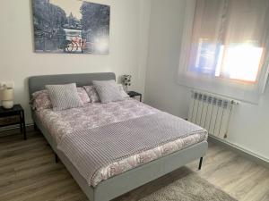 1 dormitorio con cama y ventana en A Casa Vermella con jardín a 10 minutos de Santiago de Compostela, en Ortoño