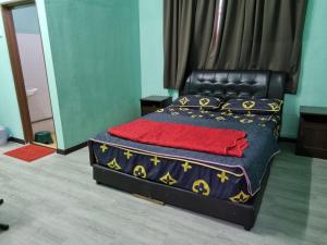 um quarto com uma cama com uma cama preta em E.R. BUDGET INN em Kota Bharu