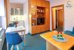 a living room with a table and a room with a kitchen at Haus Petra 131 - Ferienwohnung 1 in Juist